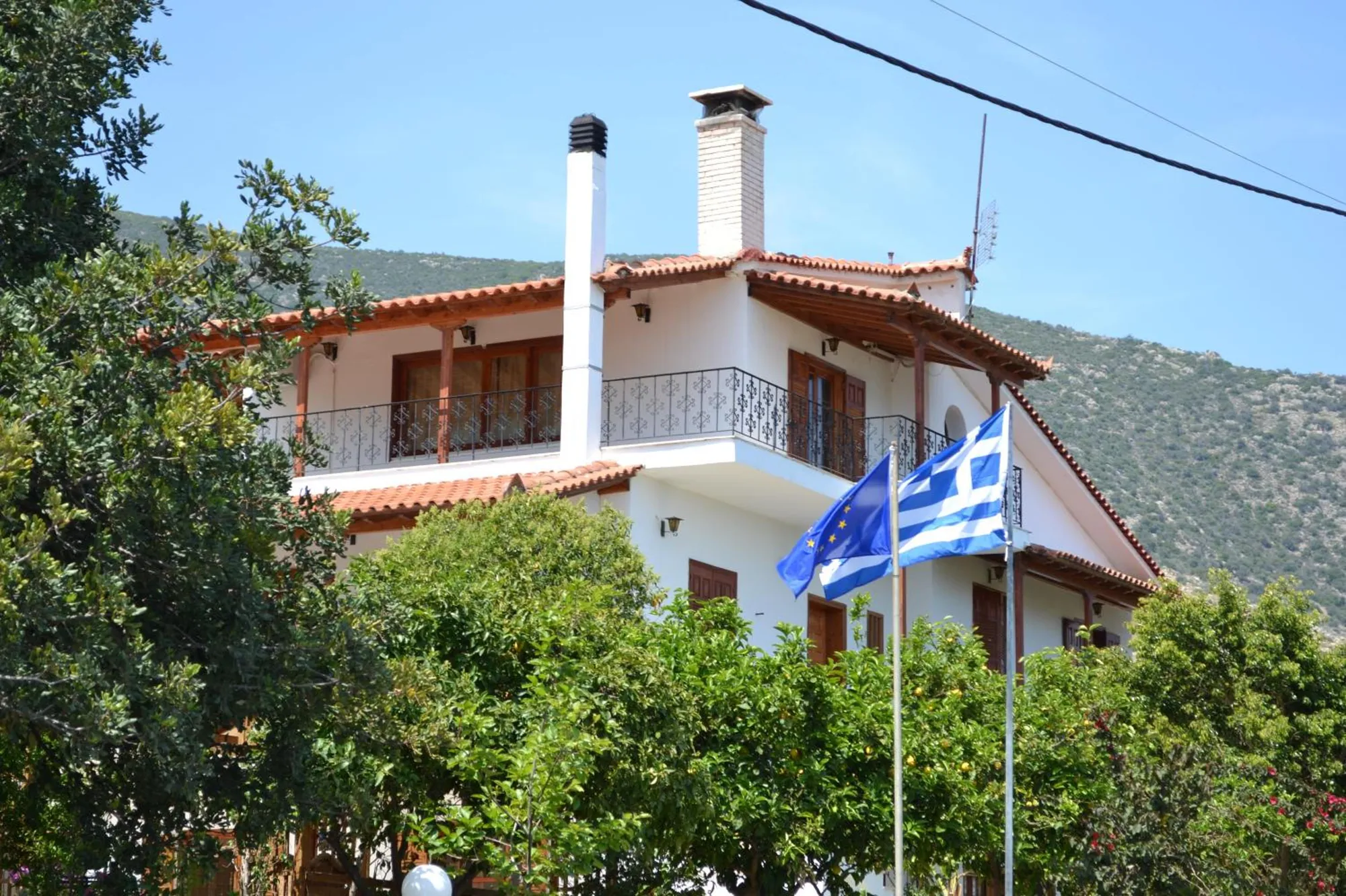 Το διώροφο σπίτι με τα μπαλκόνια μέσα στα δέντρα